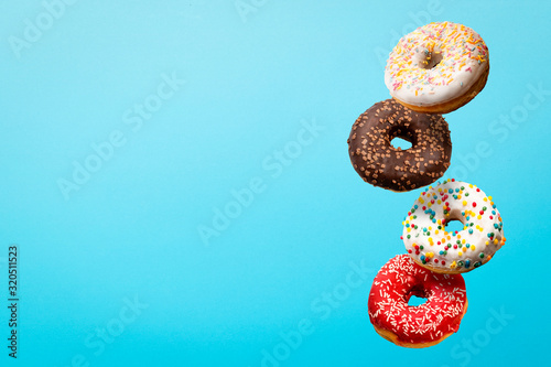 Donuts flying in the air on a blue background. Bakery, baking concept. Levitation