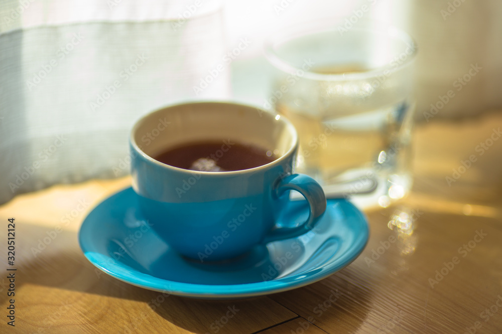 Blurred background view of a mug or coffee cup, a cup of water or a drink on the table, for customer service in a room or restaurant Blurred background view of a mug or coffee cup, a cup of water or a drink on the table, for customer service in a room or restaurant