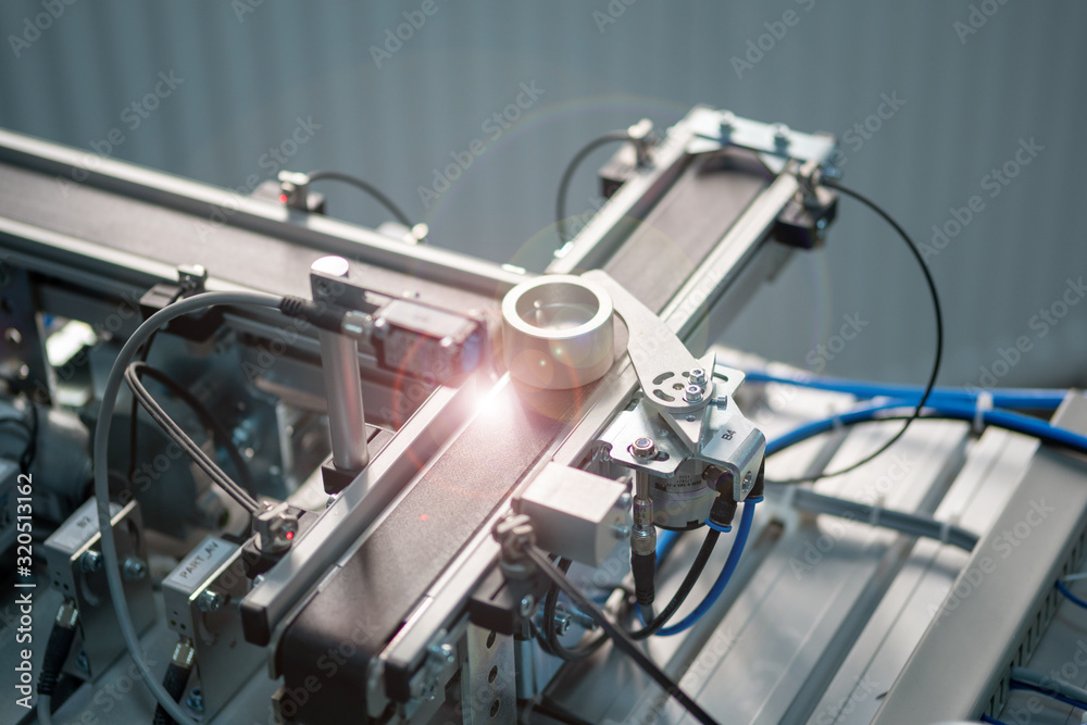 Obraz premium Industry 4.0 concept; artificial intelligence in smart factory. Close-up of product which is classified by sensors on assembly line equipped with sensors and pneumatic equipments.