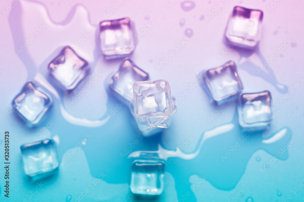 Ice cubes with water on a blue background. Abstract light. Ice concept for drinks. Banner. Flat lay, top view Ice cubes with water on a blue background. Abstract light. Ice concept for drinks. Banner. Flat lay, top view