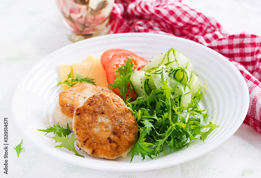 Ketogenic lunch. Chicken burger with tomato, cucumber, cheese and arugula salad without bun. Chicken patties. Healthy food. Keto/paleo diet. Ketogenic lunch. Chicken burger with tomato, cucumber, cheese and arugula salad without bun. Chicken patties. Healthy food. Keto/paleo diet.