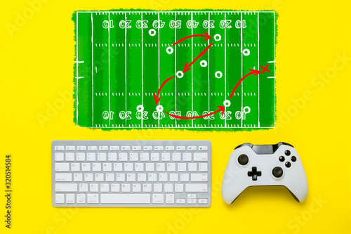 Keyboard and controller on a yellow background. Added drawing of a football field and tactical scheme. The concept of the game console. Flat lay, top view.