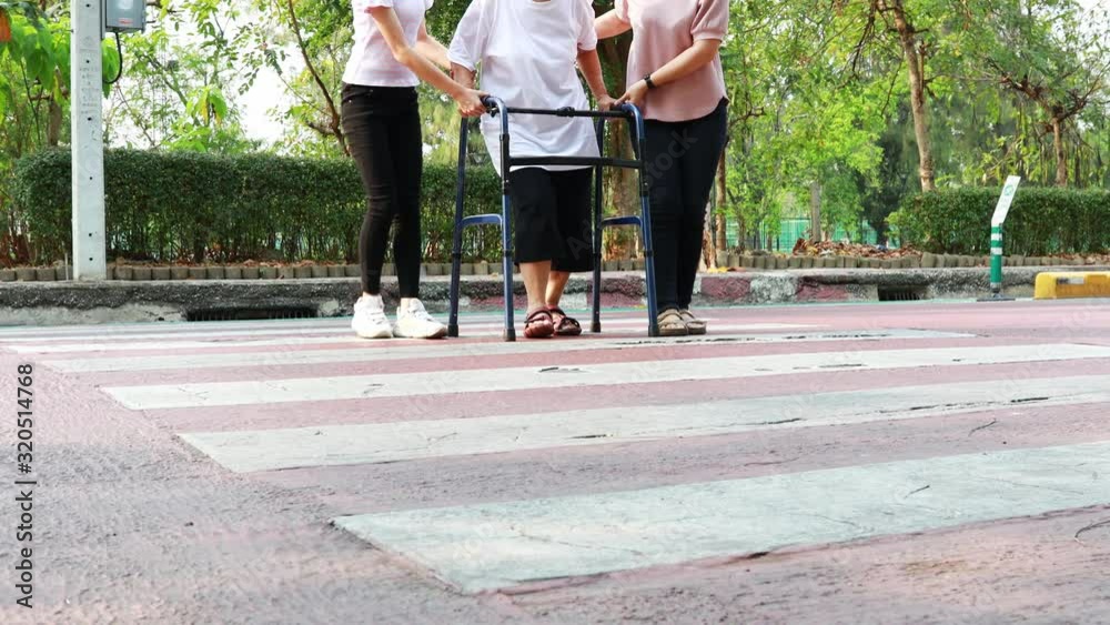 Elderly woman with walker on the crosswalk,asian family walking on ...