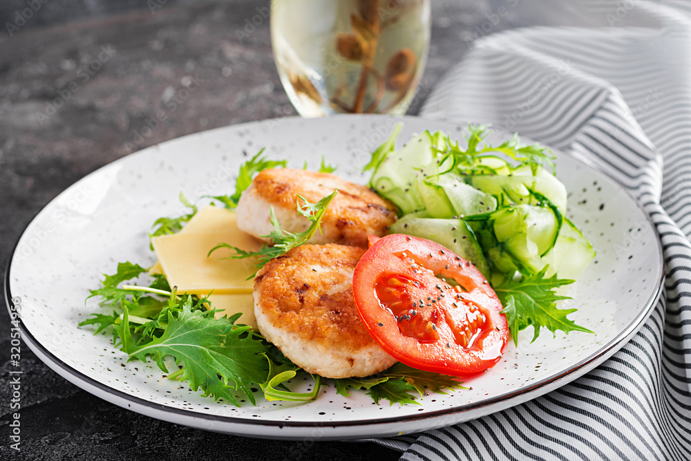 Ketogenic lunch. Chicken burger with tomato, cucumber, cheese and arugula salad without bun. Chicken patties. Healthy food. Keto/paleo diet. Ketogenic lunch. Chicken burger with tomato, cucumber, cheese and arugula salad without bun. Chicken patties. Healthy food. Keto/paleo diet.