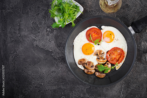 Ketogenic food. Fried egg, mushrooms and sliced tomatoes. Keto, paleo breakfast. Top view, overhead, copy space