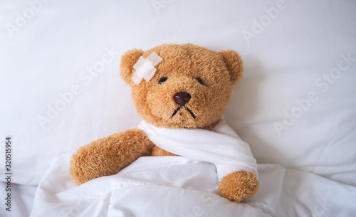 The teddy bear fell ill in the bed, injured by the accident. insurance concept