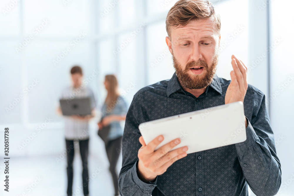 close up. frustrated man looking at the screen of his tablet. close up. frustrated man looking at the screen of his tablet.