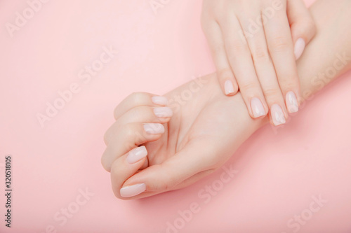 Stylish trendy nail young woman hands manicure on pink background, top view