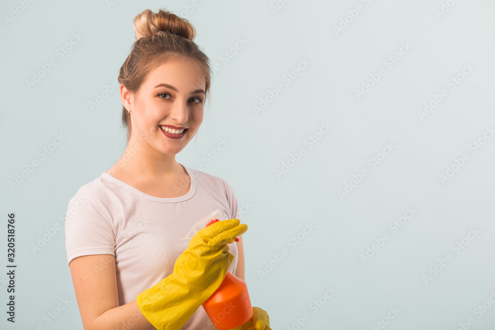 beautiful young woman in rubber gloves with a cleaning agent in her hands