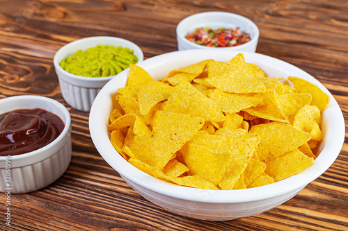 Mexican nachos with cheese. Corn chips with guacamole, salsa and tomato ketchup.