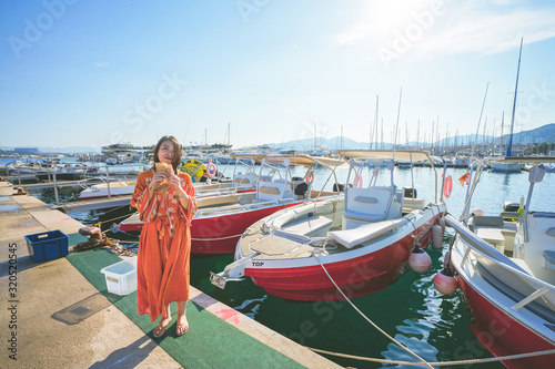 Marseille, France - August 13th, 2019:A young woman is enjoying sunshine and beautiful view in Calanques de Morgiou, Marseilles, Provence, South of France.  She looks very cheerful and happy.