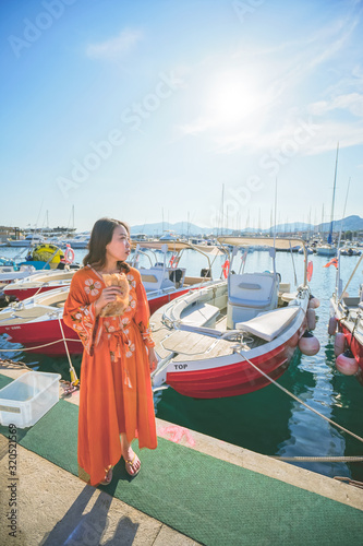 Marseille, France - August 13th, 2019:A young woman is enjoying sunshine and beautiful view in Calanques de Morgiou, Marseilles, Provence, South of France.  She looks very cheerful and happy.