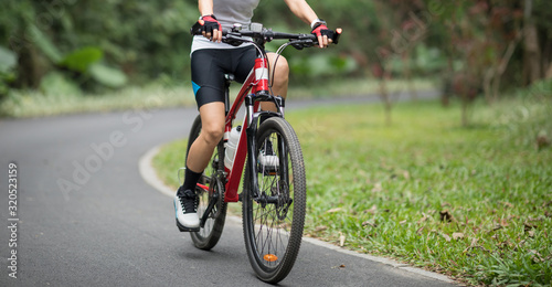 Woman cyclist riding mountain bike in park
