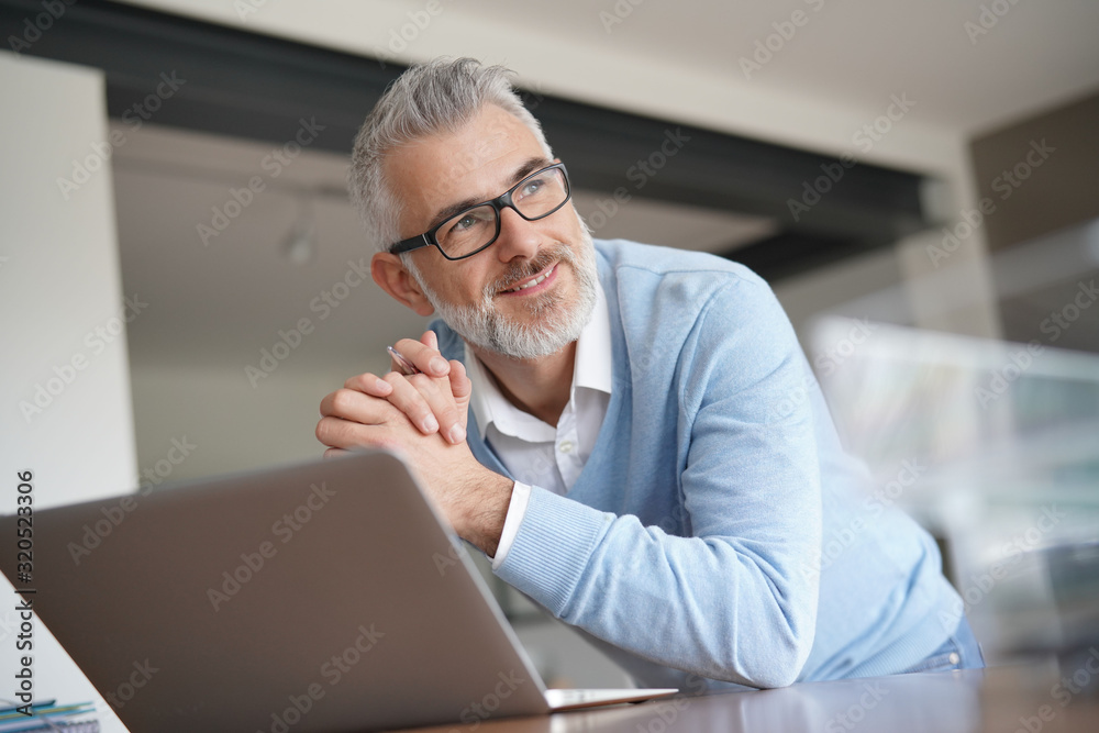 Man in office working on laptop computer Man in office working on laptop computer