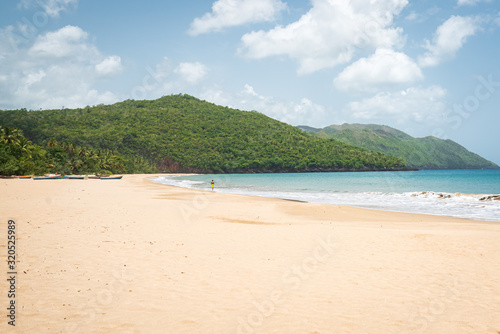 Fototapeta Naklejka Na Ścianę i Meble -  A view of tropical beach with sea, sand and blue sky,during the day on a public beach in Rincon Beach,Samana peninsula, Dominican Republic