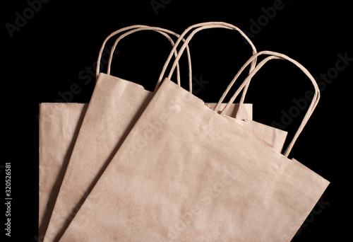 3 paper brown bags on a black background. View from above
