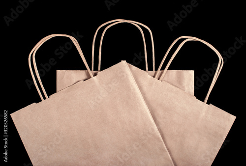 3 paper brown bags on a black background. View from above