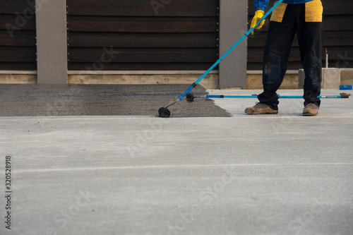 Foto Worker applies bitumen mastic on the foundation