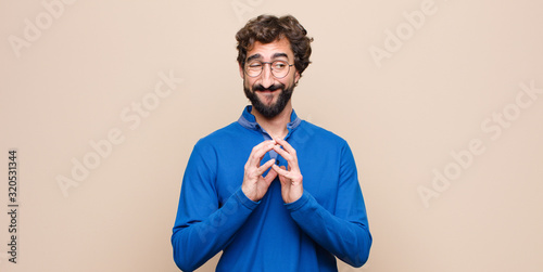 Photography young handsome man feeling proud, mischievous and arrogant while scheming an evi