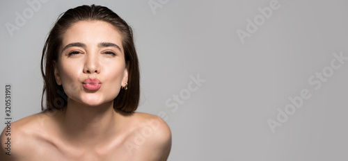 Beautiful sexy woman makes a kiss sign and looks at the camera