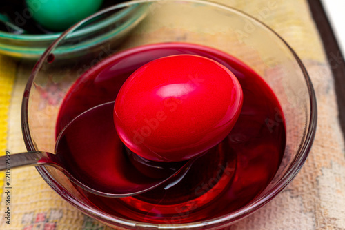 Painting, dying red eggs for Easter in glass jar