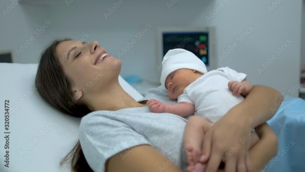 Happy family. Newborn baby sleeping in mother arms. Mom right after delivery in maternity hospital, Parturient woman holding new born child after birth labor Childbirth pregnant motherhood 4 K slow-mo