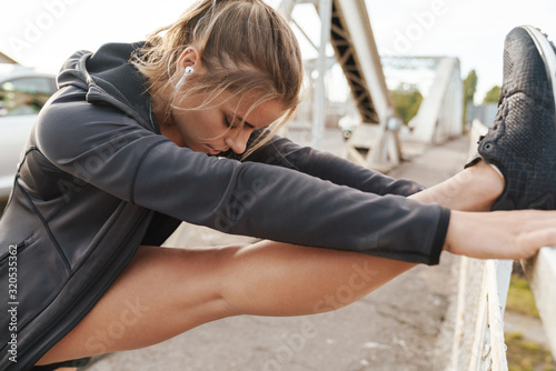 Sports fitness woman make stretching exercises outdoors. © Drobot Dean