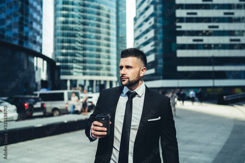 Businessman with coffee to go on street