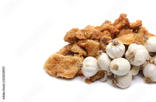 Pork cracklings, greaves with garlic cloves isolated on white background