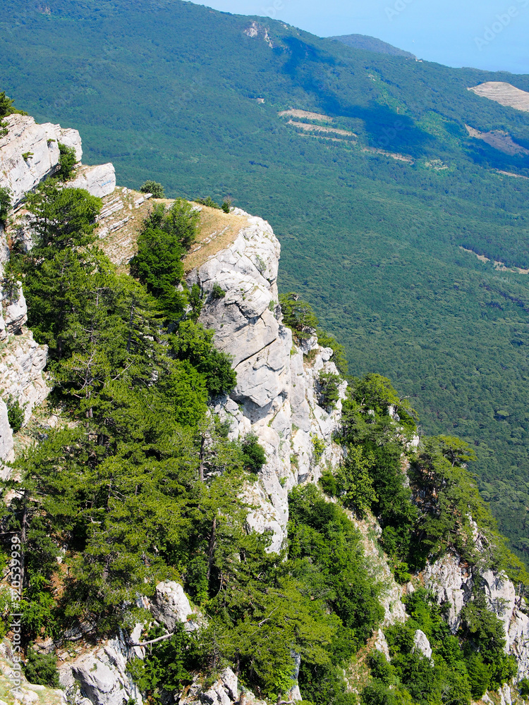 Rocky mountain slopes of the southern coast of Crimea, covered with dense vegetation. Concept of recreation and tourism, extreme sports. View of the slopes of the mountainous area of Crimea.