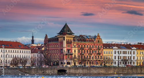 Prague, Czech Republic - Panoramic view of the riverside of Prague at winter time with traditional buildings, hotels and beautiful purple sky at sunset