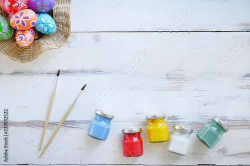 Painting eggs for easter holiday celebration on white wooden background