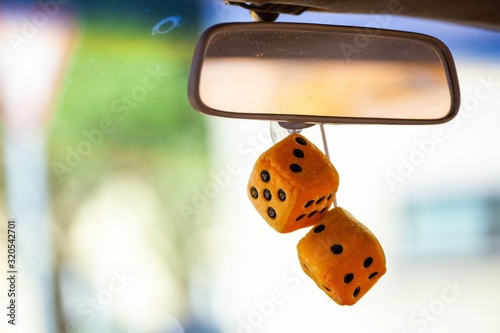 fuzzy dice haning from rear view mirror of classic car photo