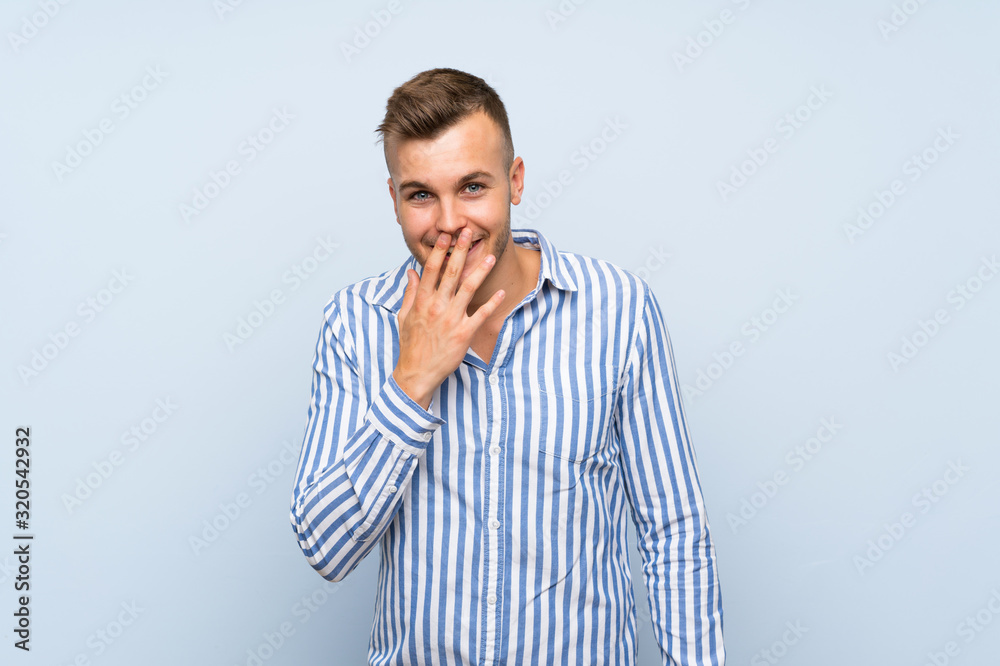 Young handsome blonde man over isolated blue background smiling a lot Young handsome blonde man over isolated blue background smiling a lot