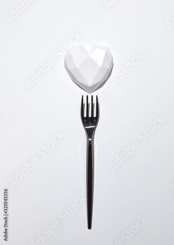 Black plaster fork with gypsum white heart .