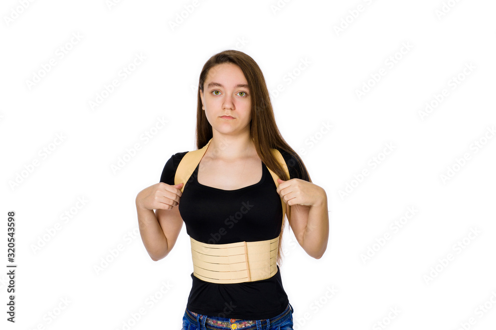 A teenager of 14 years wearing a rehabilitation corset isolated on a white background A teenager of 14 years wearing a rehabilitation corset isolated on a white background