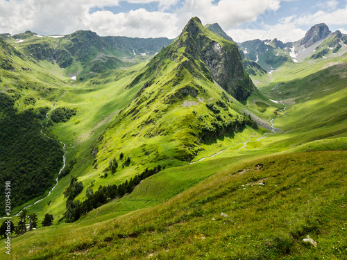 Amazing mountain landscape in Russia on sunny day. Alpine green meadow in Caucasus highlands. Idyllic valley in arkhyzmountains