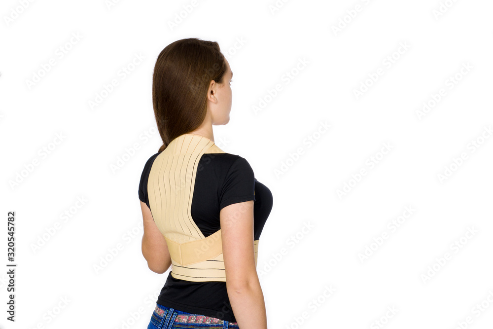 A teenager of 14 years wearing a rehabilitation corset isolated on a white background A teenager of 14 years wearing a rehabilitation corset isolated on a white background