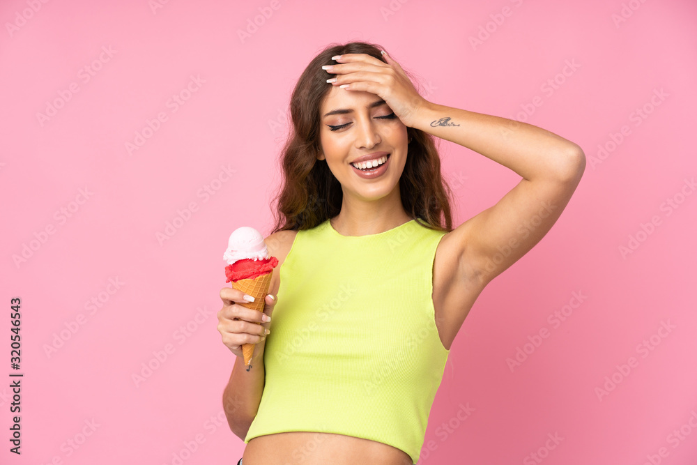 Young woman holding a cornet ice cream over isolated on a pink background has realized something and intending the solution Young woman holding a cornet ice cream over isolated on a pink background has realized something and intending the solution
