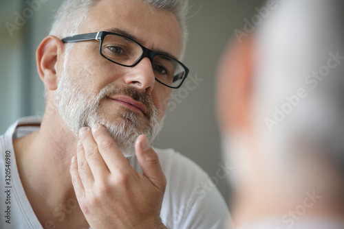 Portrait of man taking care of beard