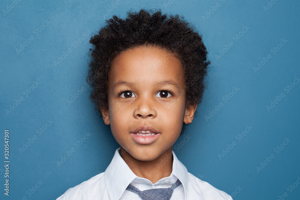 Little black kid boy student on blue background close up portrait Little black kid boy student on blue background close up portrait