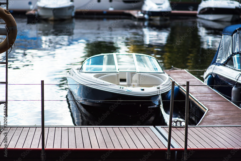 Fototapeta premium Small motor boat at anchor by rope in Replot pier