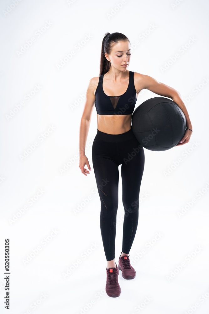 Fit and strong female athlete working out with a medicine ball to get better core strength and stability Fit and strong female athlete working out with a medicine ball to get better core strength and stability