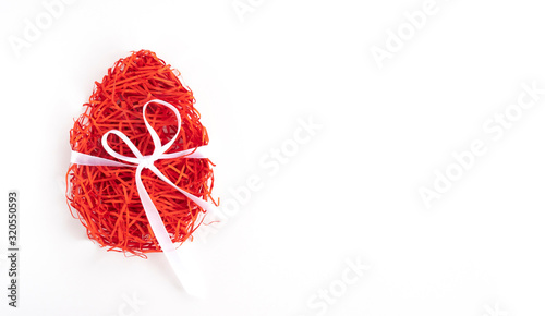 Easter creative composition.  Flat lay with shape of easter egg made of red paper filler and ribbon on white background. Minimal spring concept. Copy space