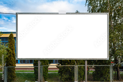 Blank advertising billboard mockup in front of industrial building