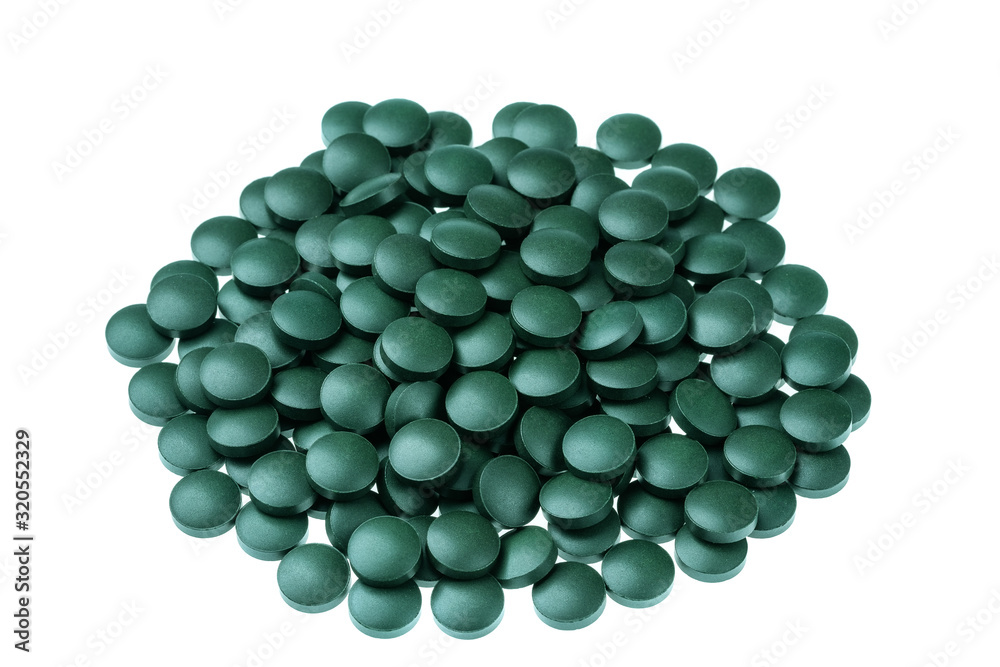Vitamin and mineral supplements for vegetarians spirulina in tablets on a white background, close-up. Vitamin and mineral supplements for vegetarians spirulina in tablets on a white background, close-up.