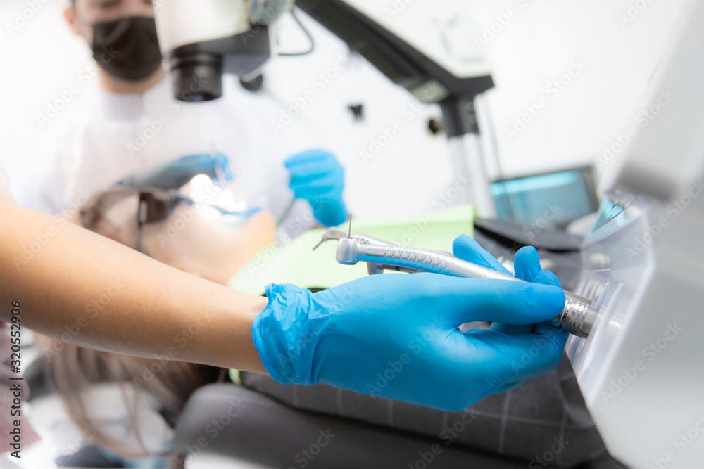 Close up of dentist in gloves choosing dental tool Close up of dentist in gloves choosing dental tool