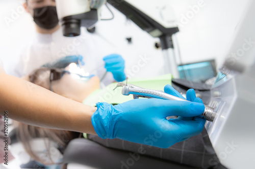 Close up of dentist in gloves choosing dental tool