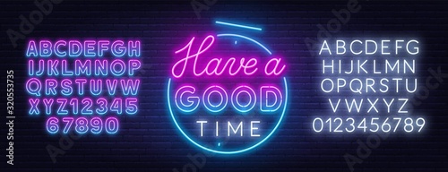 Have a good time neon lettering on brick wall background. Neon alphabet on a dark background.