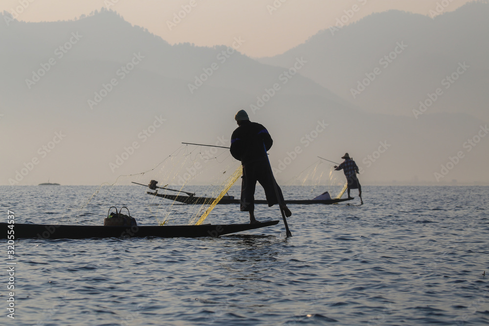 Naklejka premium The fisherman of the Inle Lake arranges fishing nets